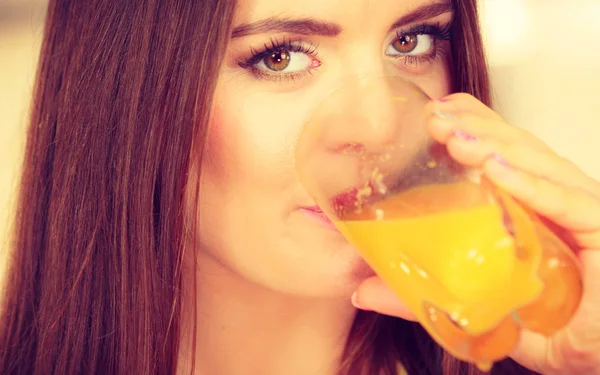 Frau in Küche trinkt frischen Orangensaft — Stockfoto