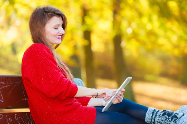 Kvinna på bänken i parken med surfplatta. — Stockfoto