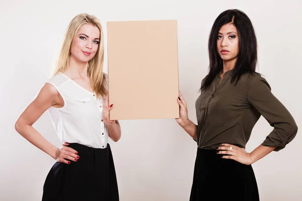 Duas mulheres segurando placa em branco — Fotografia de Stock