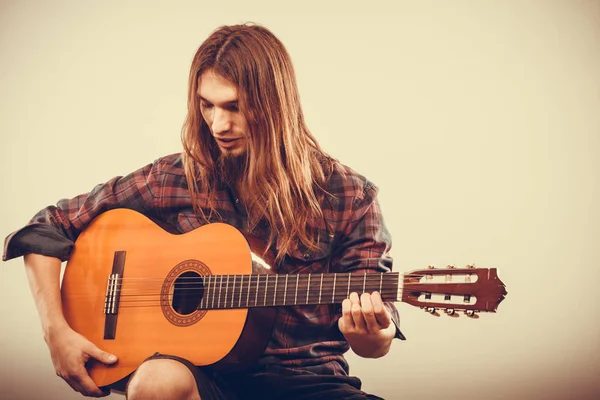 Homme assis jouant de la guitare . — Photo