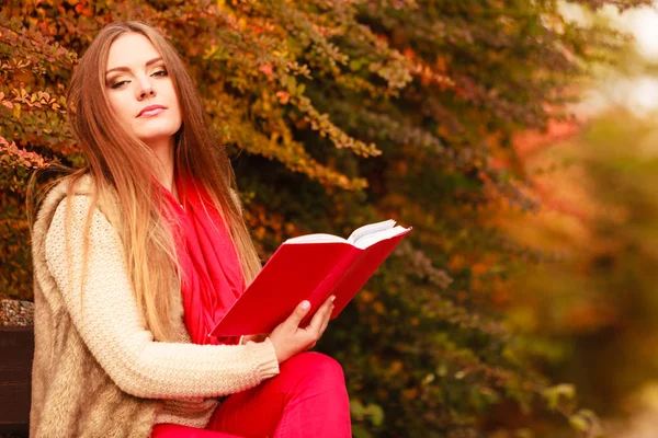 Kvinnan avkopplande i höstlig park läsa bok — Stockfoto