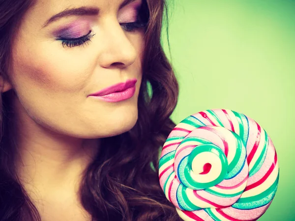 Chica sonriente con caramelos de piruleta en verde — Foto de Stock