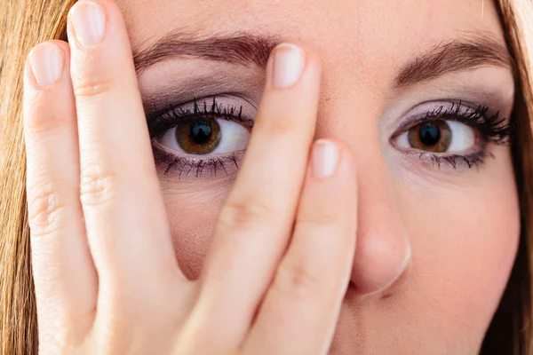 Mujer cubrir la cara mirada a través de los dedos . —  Fotos de Stock