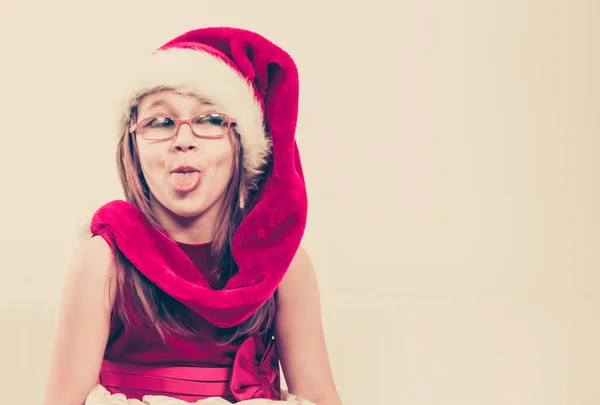 바보 같은 얼굴을 만드는 산타 모자에 소녀 — 스톡 사진