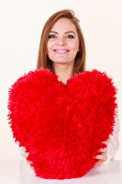 Mulher feliz segurando travesseiro em forma de coração — Fotografia de Stock