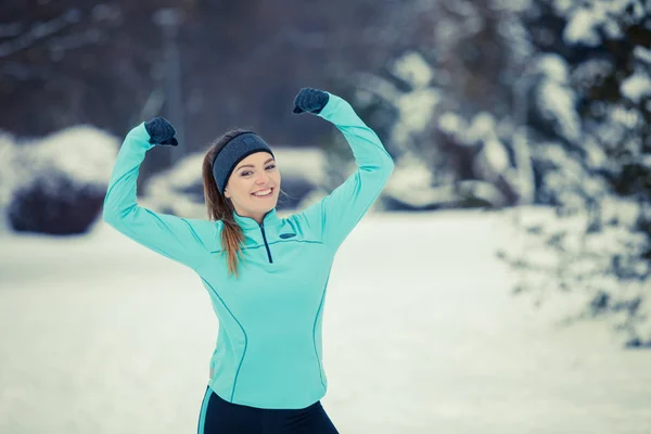 Стоїть дівчина в зимовому спортивному одязі, фоні дерев — стокове фото