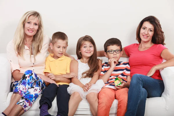 Una famiglia felice. Madri e bambini sul divano di casa . — Foto Stock