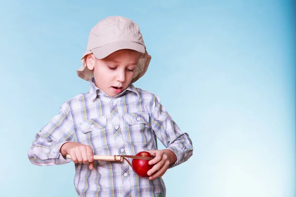 Genç çocuk kullanım sapan atışı elma tutun. — Stok fotoğraf