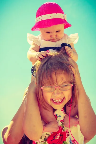 Toddler girl giving her little sister a piggyback — Stock Photo, Image