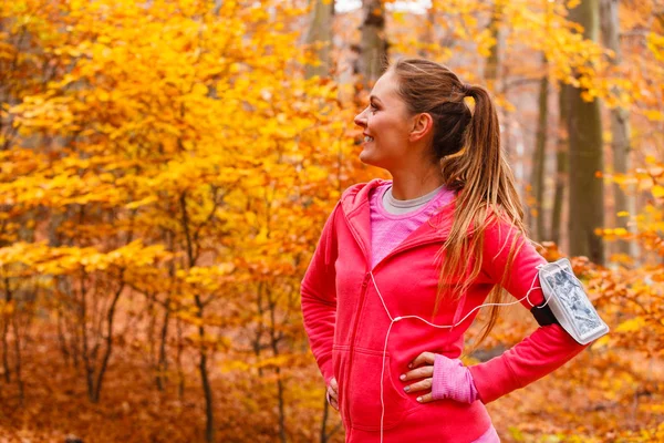 Sportieve meisje rust in bos luisteren muziek. — Stockfoto