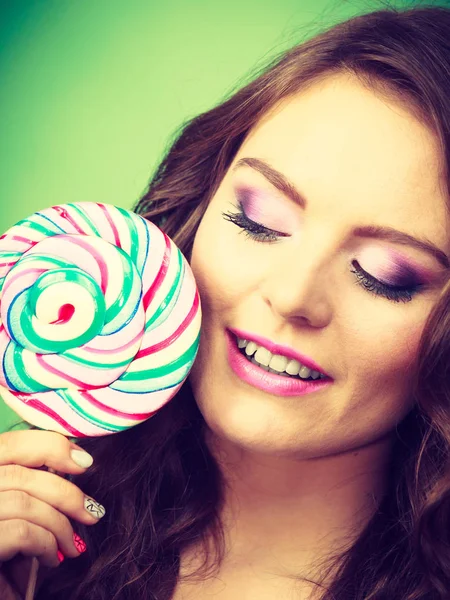 Lächelndes Mädchen mit Lutscher-Bonbons auf Grün — Stockfoto