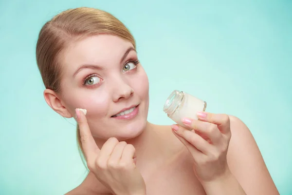 Mujer aplicando crema en su cara de piel. —  Fotos de Stock