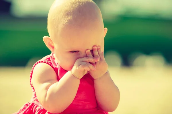 Kleine baby gezicht in handen verbergen — Stockfoto