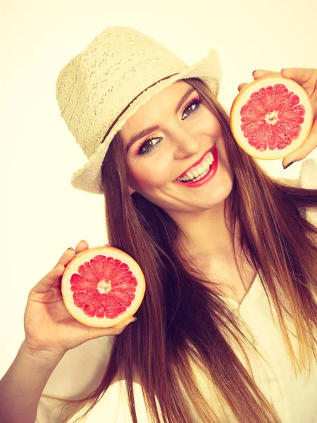 Vrouw houdt twee helften pompelmoes citrusvruchten in handen — Stockfoto