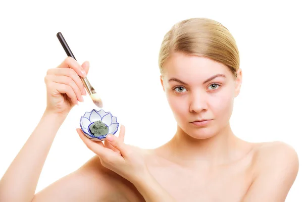 Skin care. Woman applying clay mud mask on face. — Stock Photo, Image