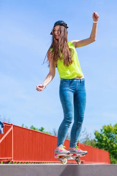 Dospívající dívka bruslař na koni skateboard na ulici. — Stock fotografie