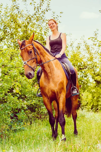 Giovane donna seduta su un cavallo — Foto Stock