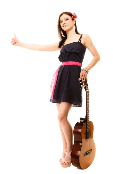 Dziewczyna z gitara thumbing i autostop na białym tle — Zdjęcie stockowe