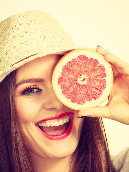 Kobieta trzyma pół grejpfruta owoców cytrusowych w ręku — Zdjęcie stockowe
