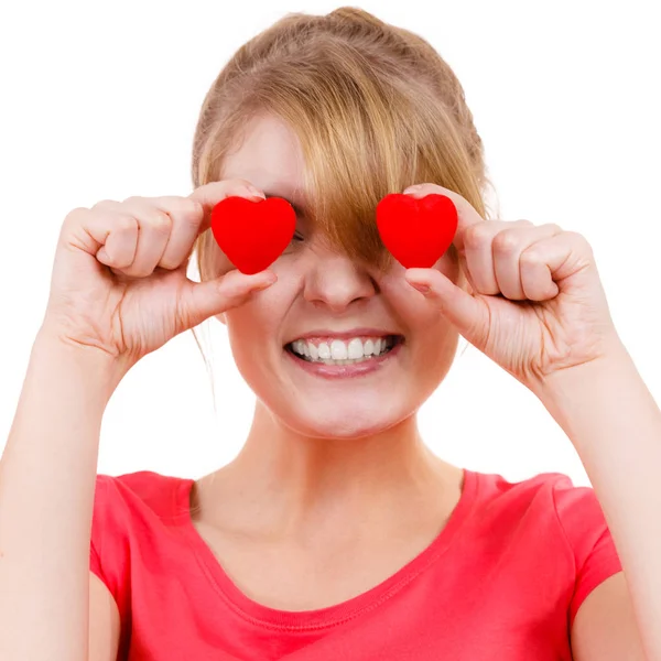 Mujer divertida sostiene corazones rojos sobre los ojos — Foto de Stock