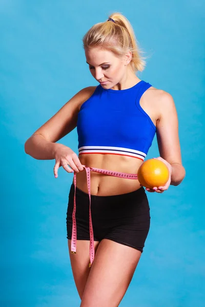 Mujer ajuste chica con cinta métrica y pomelo — Foto de Stock