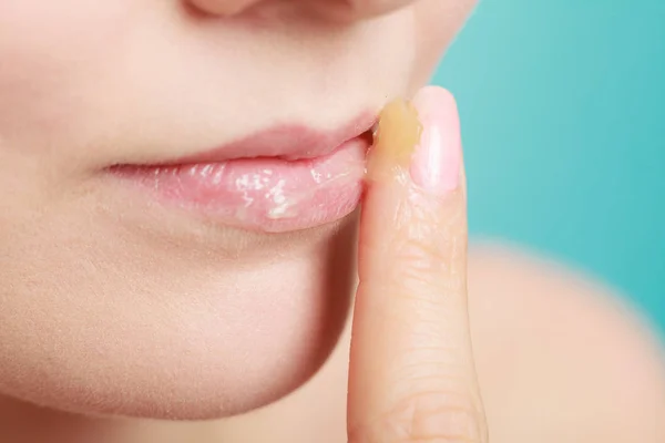 Frau cremt Lippen mit Feuchtigkeitscreme ein — Stockfoto
