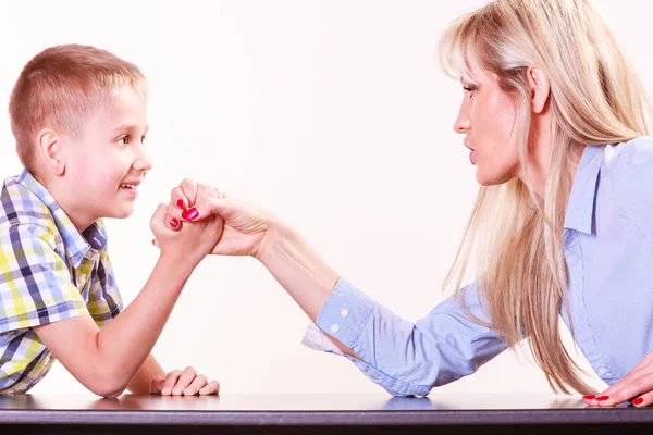 Mother and son arm wrestle sit at table. — Stock Photo, Image