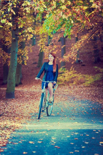 Kızıl saçlı Bayan parkta Bisiklete binme. — Stok fotoğraf