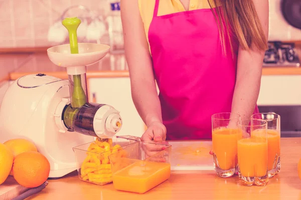 Mulher derramando suco de laranja bebida em vidro — Fotografia de Stock