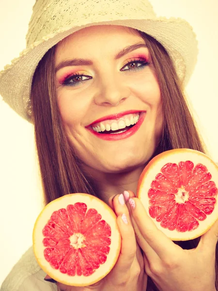 Mulher segura duas metades de frutas cítricas de toranja nas mãos — Fotografia de Stock