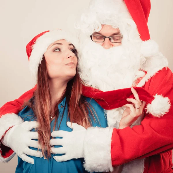 Santa Claus aanraken van vrouw met christmassy hoed — Stockfoto