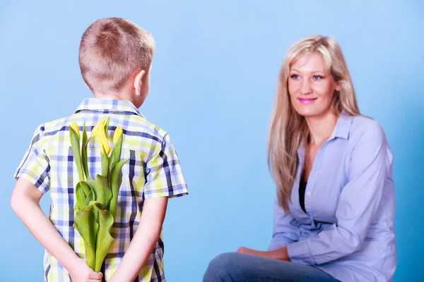 Little boy with mother hold flowers behind back. — Stock Photo, Image