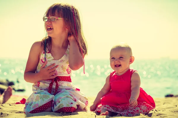 Menina da criança se divertindo com a criança na praia . — Fotografia de Stock
