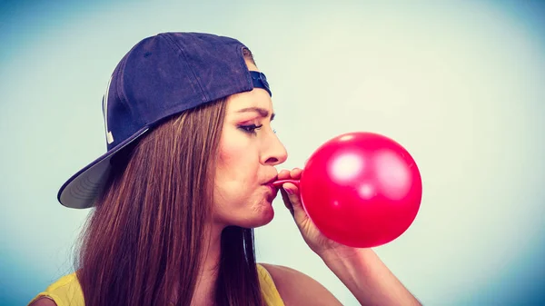 Adolescente menina soprando balão vermelho . — Fotografia de Stock