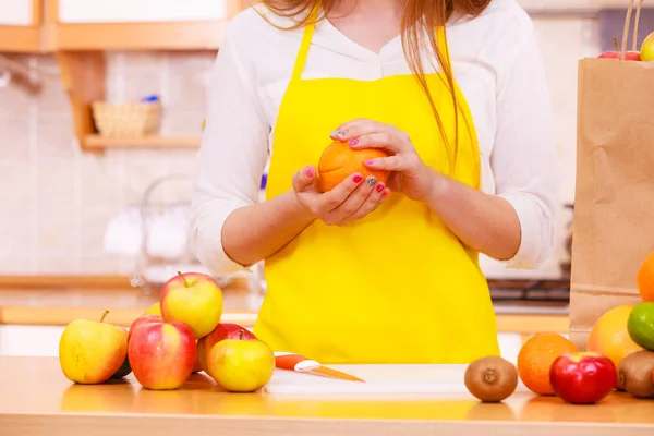 Mulher dona de casa na cozinha com muitos frutos — Fotografia de Stock