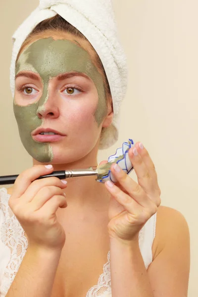 Femme appliquant avec un masque de boue d'argile brosse sur son visage — Photo