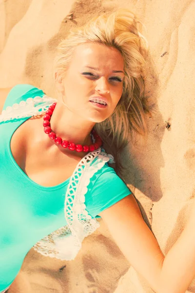 Mulher loira deitada na areia . — Fotografia de Stock