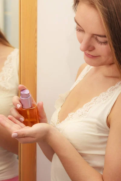Mujer cuidando su cabello largo aplicando aceite cosmético —  Fotos de Stock
