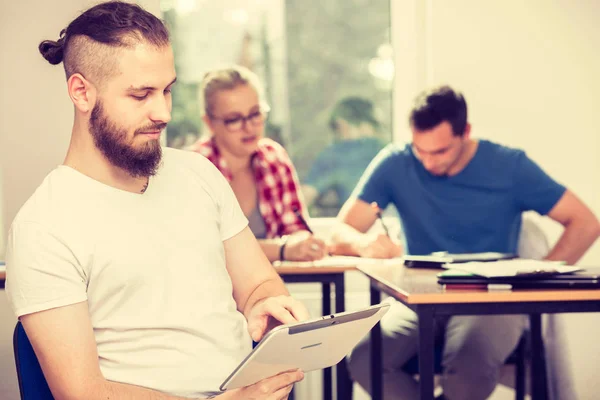 Mannelijke student met tablet voor haar klasgenoten — Stockfoto