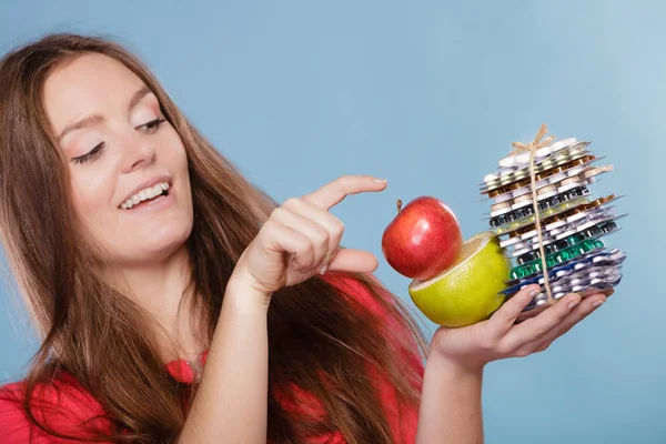 Mulher segurando pílulas e frutas. Serviços de saúde — Fotografia de Stock