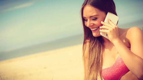 Женщина на пляже разговаривает по мобильному телефону . — стоковое фото