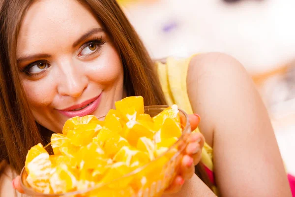 Mujer sostiene cuenco lleno de frutas de naranja en rodajas — Foto de Stock