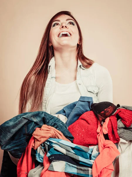 Χαμογελαστό κορίτσι κρατήστε σωρός του ρούχα. — Φωτογραφία Αρχείου