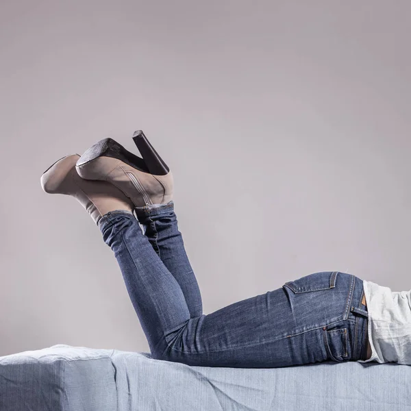 De benen van de vrouw in denim broek hoge hakken schoenen — Stockfoto