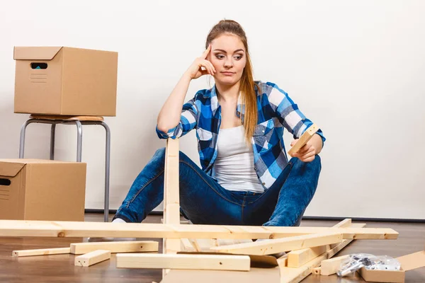 Woman moving into apartment assembly furniture. — Stock Photo, Image