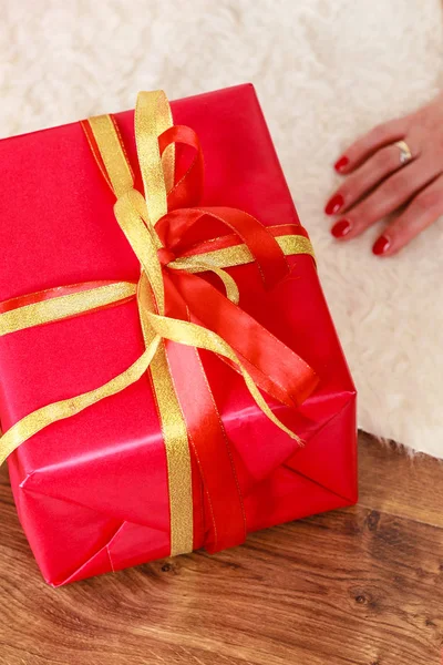 Frauenhände mit roter Geschenkbox — Stockfoto