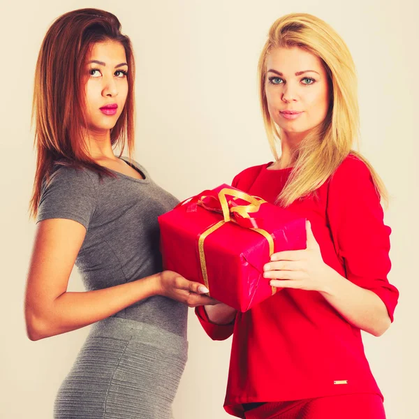 Dos mujeres de moda con regalo de caja roja . — Foto de Stock