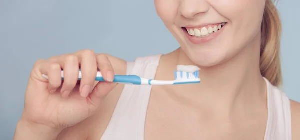 Kvinna håller tandborste med tandkräm rengöring tänder — Stockfoto