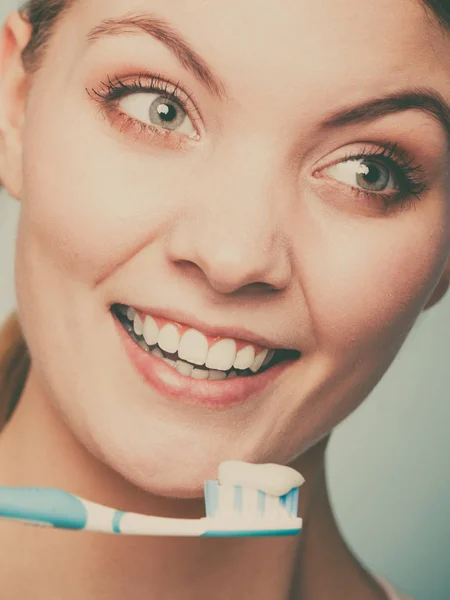Mujer sostiene cepillo de dientes con pasta de dientes limpieza de dientes —  Fotos de Stock