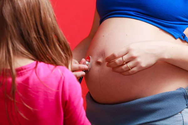 Filha olhando grávida mãe barriga grande — Fotografia de Stock